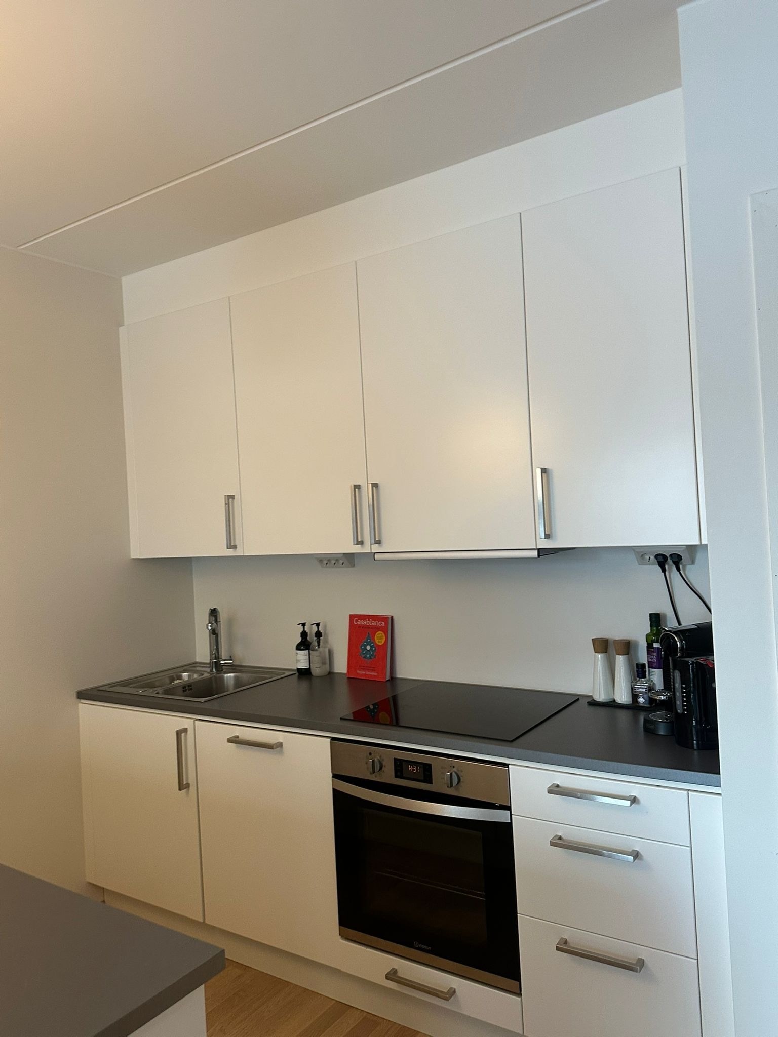 Fullt innredet kjøkken med integrerte hvitevarer